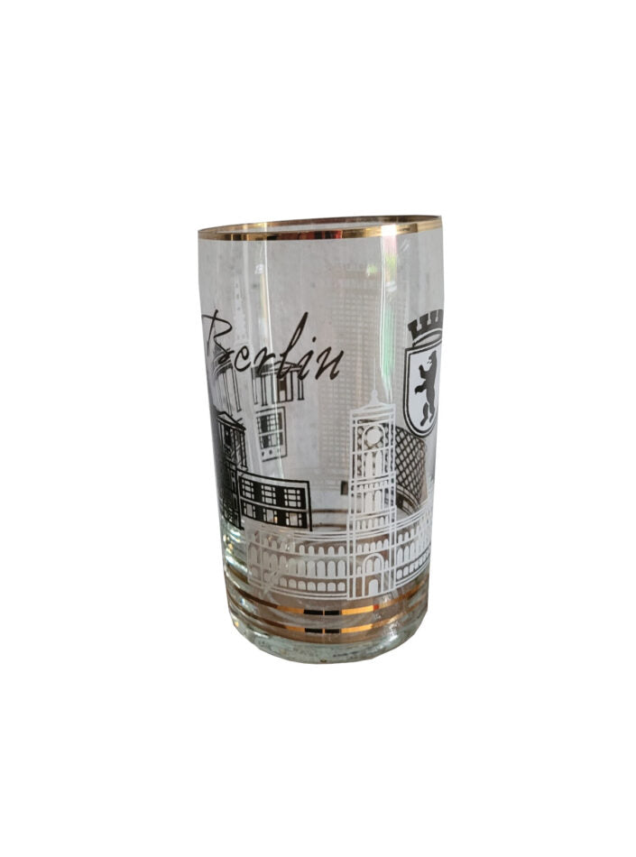 „DDR-Trinkglas mit Goldrand, ca. 1970er Jahre. Motiv zeigt Berliner Sehenswürdigkeiten wie Brandenburger Tor, Fernsehturm und Berliner Bär. Höhe ca. 11 cm, Durchmesser ca. 6,5 cm.“