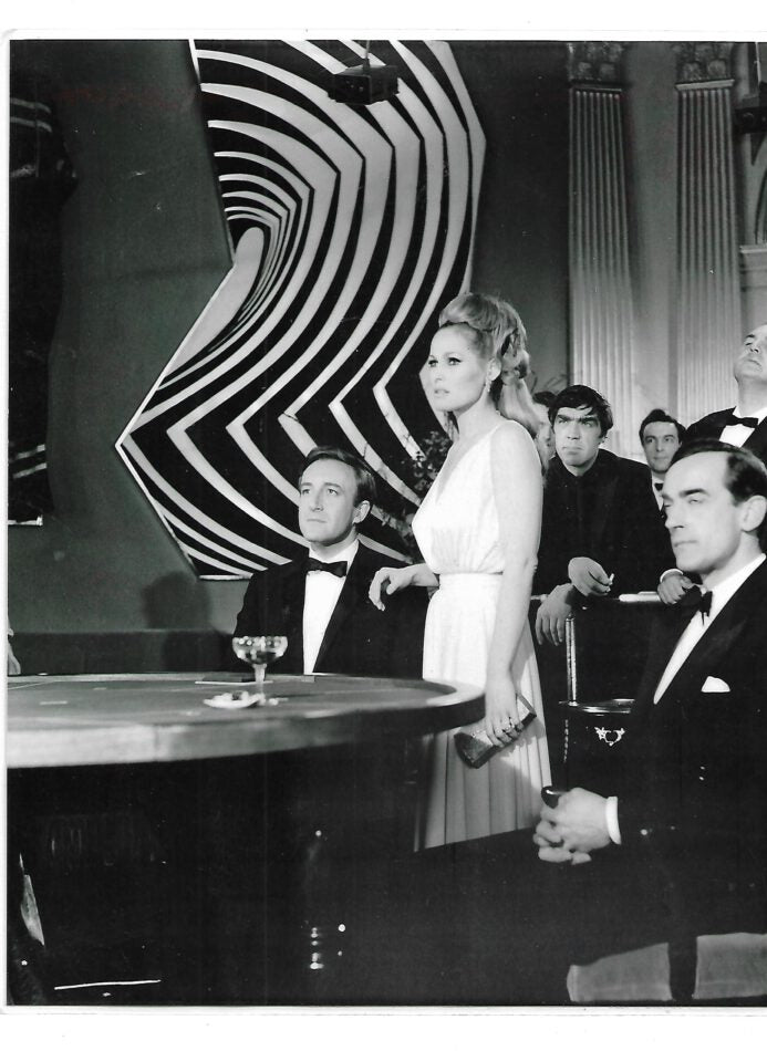 „Laminiertes Hochglanzfoto von Ursula Andress im Format ca. 25,5 × 20 cm. Motiv zeigt die Schauspielerin in ikonischer Pose, bekannt als erstes Bondgirl aus ‚James Bond – 007 jagt Dr. No‘. Glänzende Oberfläche, ideal als Sammlerstück oder Wanddeko
