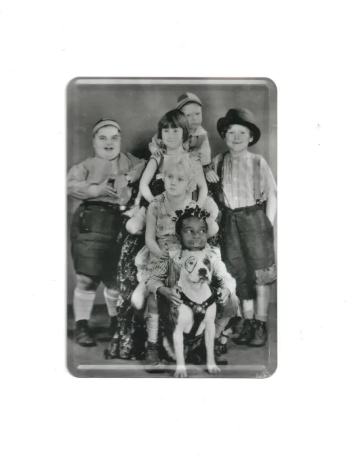 Schwarz-weiße Blechpostkarte mit Gruppenfoto von sechs Kindern und einem Hund mit Kreis um das Auge; Vintage-Motiv aus der Serie „Die kleinen Strolche“.
