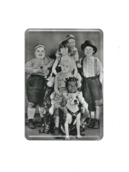 Schwarz-weiße Blechpostkarte mit Gruppenfoto von sechs Kindern und einem Hund mit Kreis um das Auge; Vintage-Motiv aus der Serie „Die kleinen Strolche“.