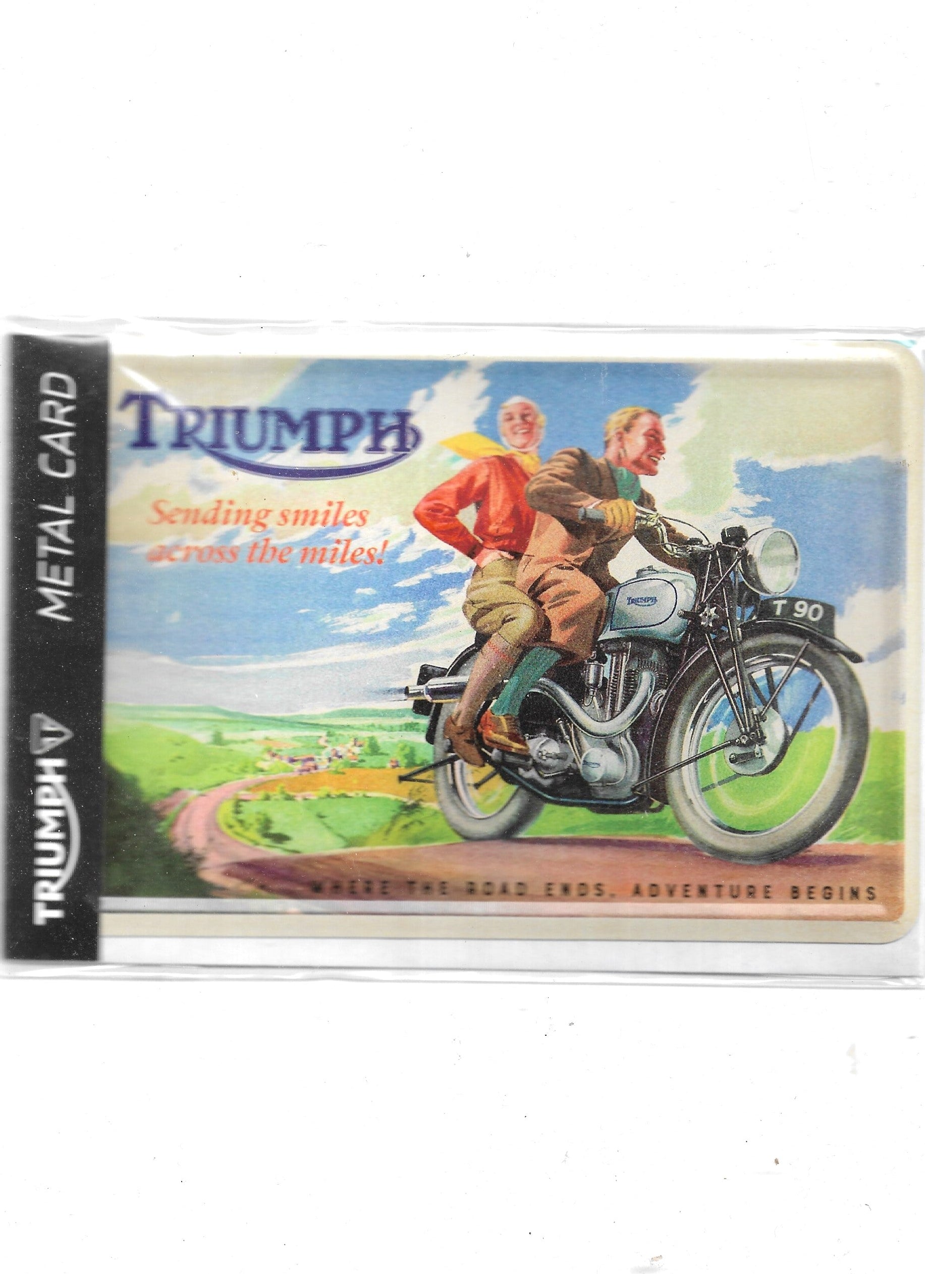 „Nostalgische Blechpostkarte ‚Triumph – sending smiles across the miles!‘, 10 × 14 cm, gewölbt und randgeprägt, aus Metall mit Papierbeschichtung. Fröhliches Retro‑Motiv im Vintage‑Design.“