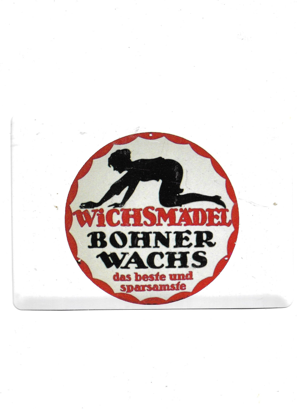 Nostalgische Blechpostkarte im Querformat mit historischer Werbung für Wichsmädel Bohnerwachs. Im rotrandigen Kreis ist die schwarze Silhouette einer knienden Frau beim Bohnern sowie die Aufschrift "Wichsmädel Bohnerwachs - das beste und sparsamste" zu sehen.