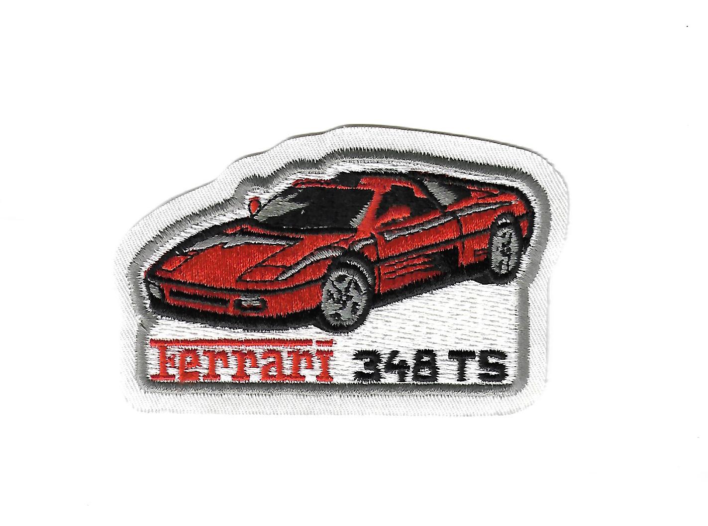 Aufnäher mit Ferrari-Logo und Modellbezeichnung „348 TS“; rechteckig, Maße ca. 10,5 × 8 cm, aus Stoff gefertigt, mit Bügelfläche auf der Rückseite zum einfachen Aufbügeln auf Kleidung oder Accessoires; Neuware, detailreich bestickt, rot-schwarzes Design.