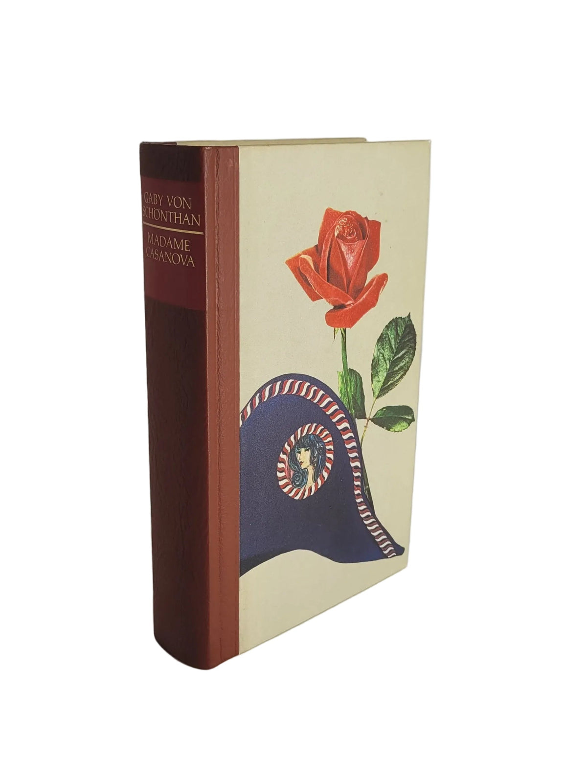 Gebundenes Buch "Madame Casanova" von Gaby von Schönthan mit rotbraunem Buchrücken und einer Illustration einer roten Rose über einem Hut aus der Napoleon-Zeit auf hellem Einband.