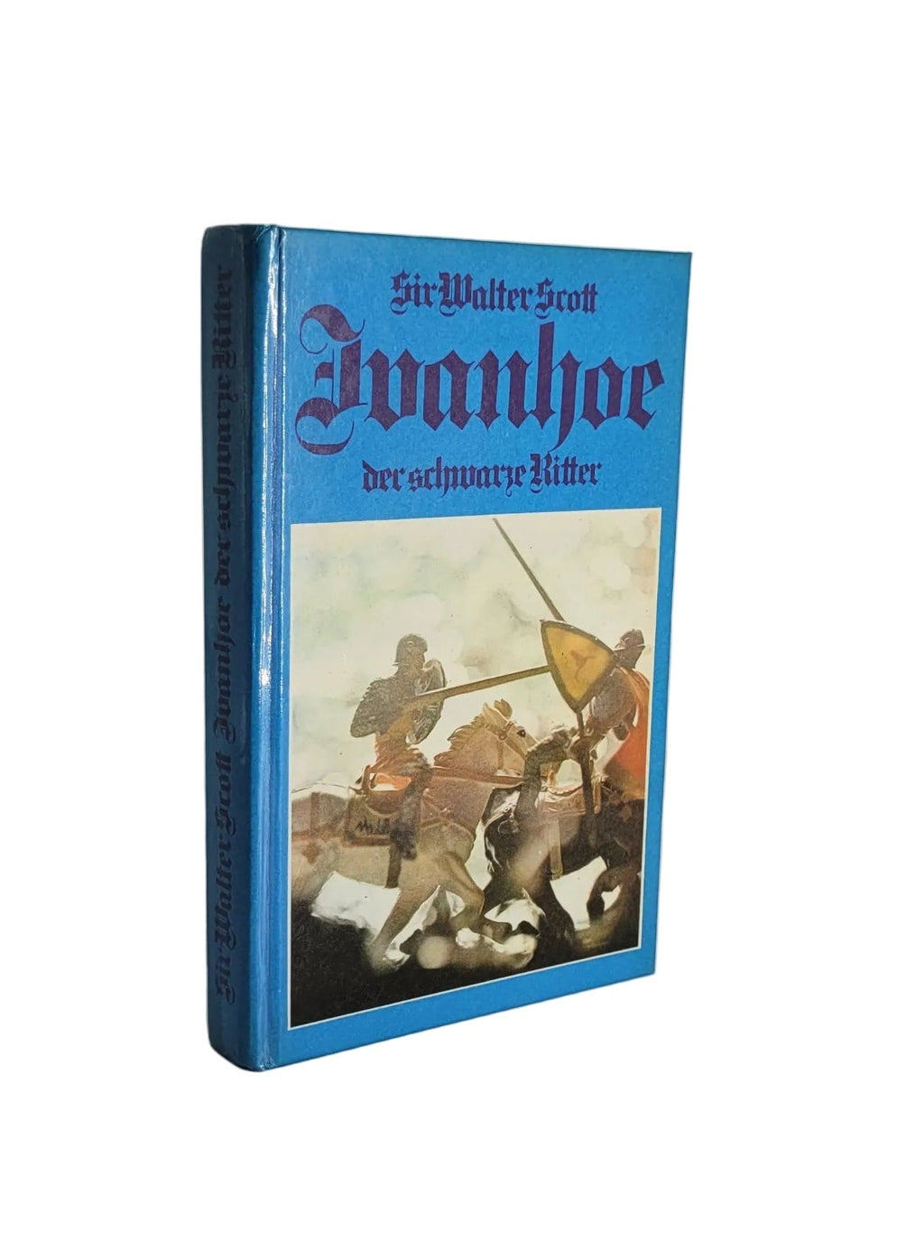 Vorderseite des blauen Kinder- und Jugendbuchs „Ivanhoe – Der schwarze Ritter“ von Sir Walter Scott (Aversa Verlag Vaduz) mit farbigem Turnier-Motiv zweier gegeneinander reitender Ritter.