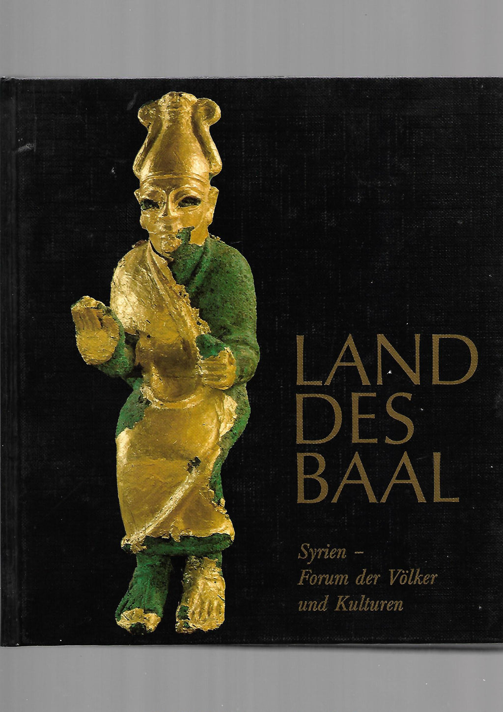 „Buchcover des Ausstellungskatalogs Land des Baal – Syrien, Große Orangerie Berlin‑Charlottenburg 1982, Hardcover.“ „Innenansicht des Ausstellungskatalogs Land des Baal – Syrien mit Fotografien archäologischer Funde und kulturhistorischen Texten.“