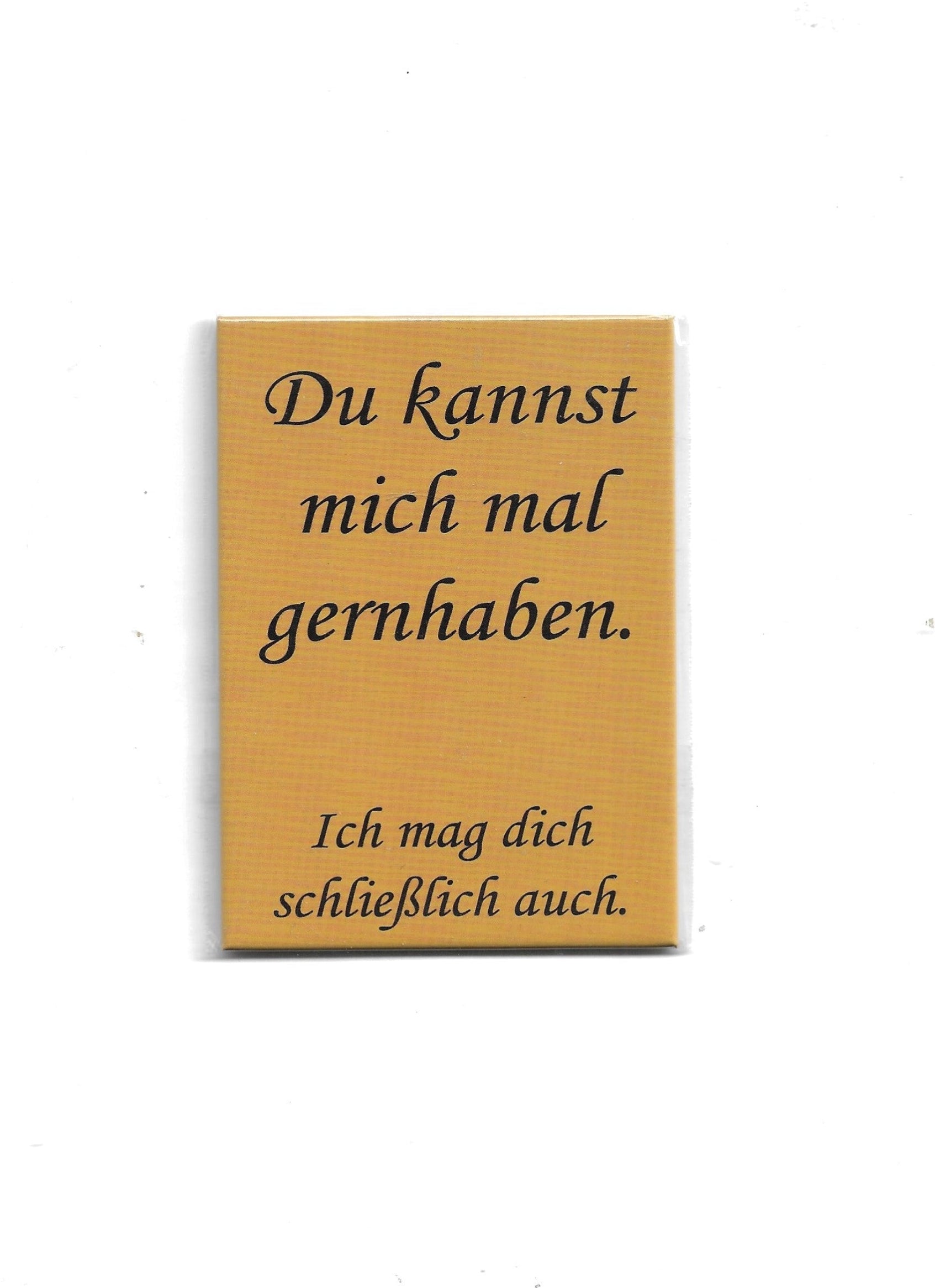 „Rechteckiger Kühlschrankmagnet ‚Du kannst mich mal gernhaben‘; farbig bedrucktes Metall; vollflächiger Magnet; Format ca. 9 × 6,5 cm; geeignet zum Befestigen mehrerer Notizzettel; EAN 4038732110021.“