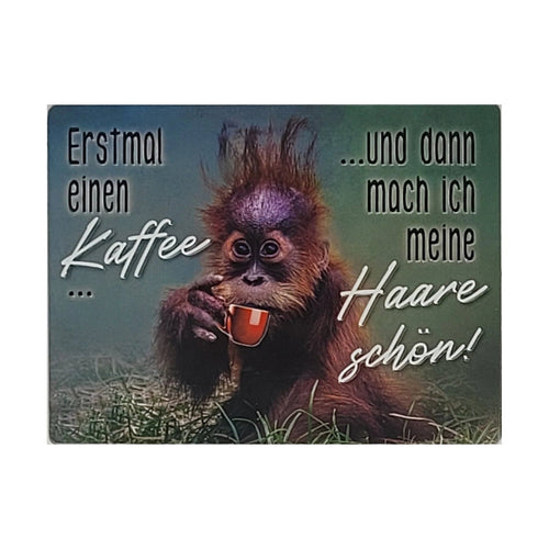 „Großer Magnet mit lustigem Orang-Utan-Motiv, der aus einer roten Tasse trinkt, dazu der Spruch ‚Erstmal einen Kaffee … und dann mach ich meine Haare schön!‘.“