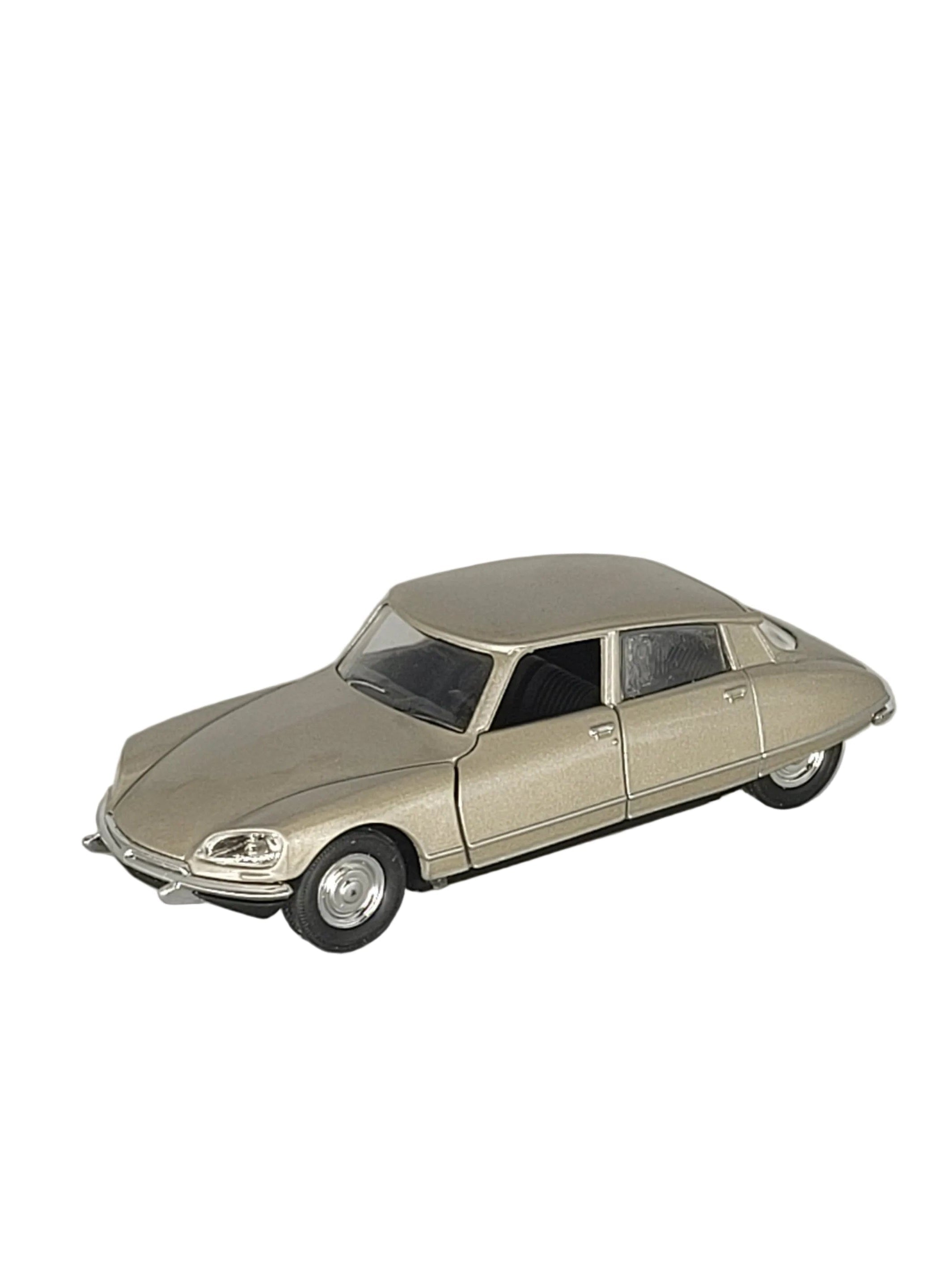 „Champagnerfarbenes Modellauto Citroën DS 23, Baujahr 1973, im Maßstab 1:34. Das Miniaturfahrzeug besteht aus Metall mit Kunststoffteilen, misst etwa 12 × 4,5 × 4 cm und besitzt einen Friktionsmotor. Das Modell zeigt die charakteristischen Linien der klassischen Citroën DS.“