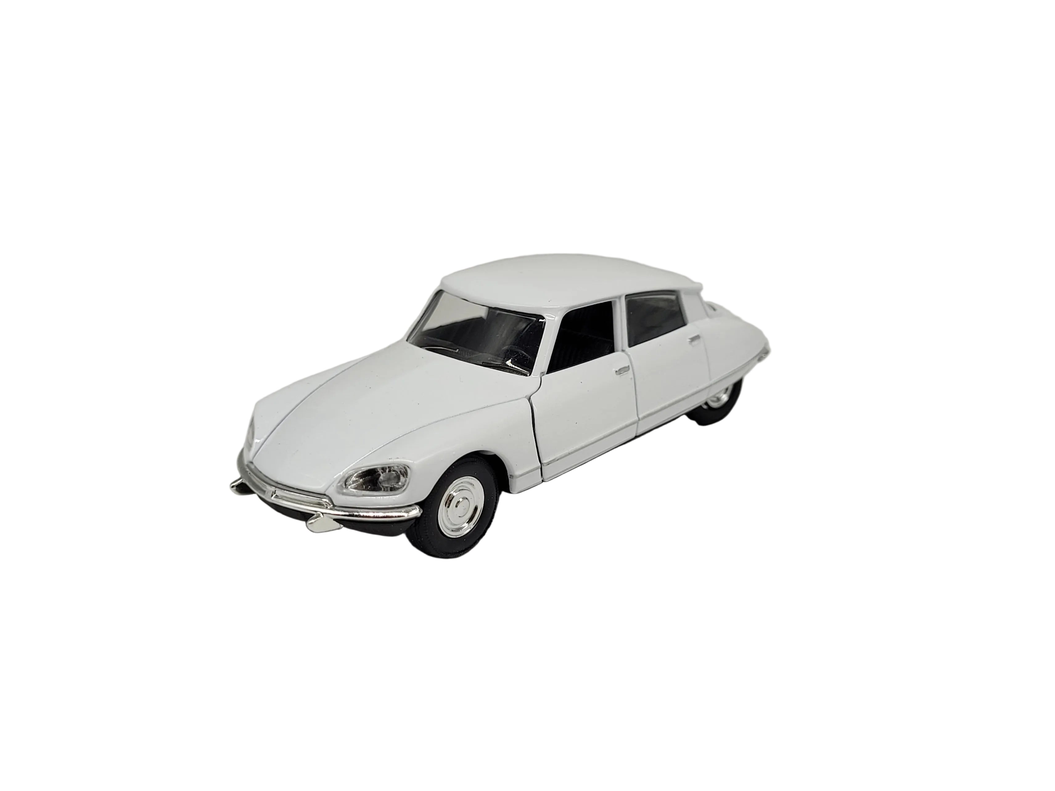 „Weißes Modellauto Citroën DS 23, Baujahr 1973, im Maßstab 1:34. Das Miniaturfahrzeug besteht aus Metall mit Kunststoffteilen, misst etwa 12 × 4,5 × 4 cm und besitzt einen Friktionsmotor. Das Modell zeigt die charakteristischen Linien der klassischen Citroën DS.“