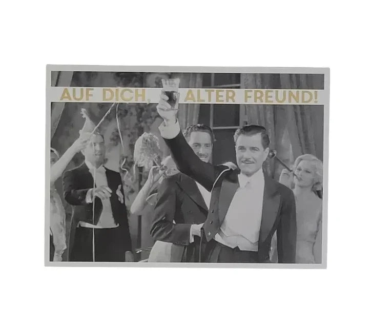 „Schwarz-weiße Postkarte mit einem Mann im Smoking, der ein Glas erhebt, umgeben von applaudierenden Gästen. Goldener Schriftzug: ‚AUF DICH ALTER FREUND!‘ – ein festlicher Gruß voller Nostalgie und Wertschätzung.“