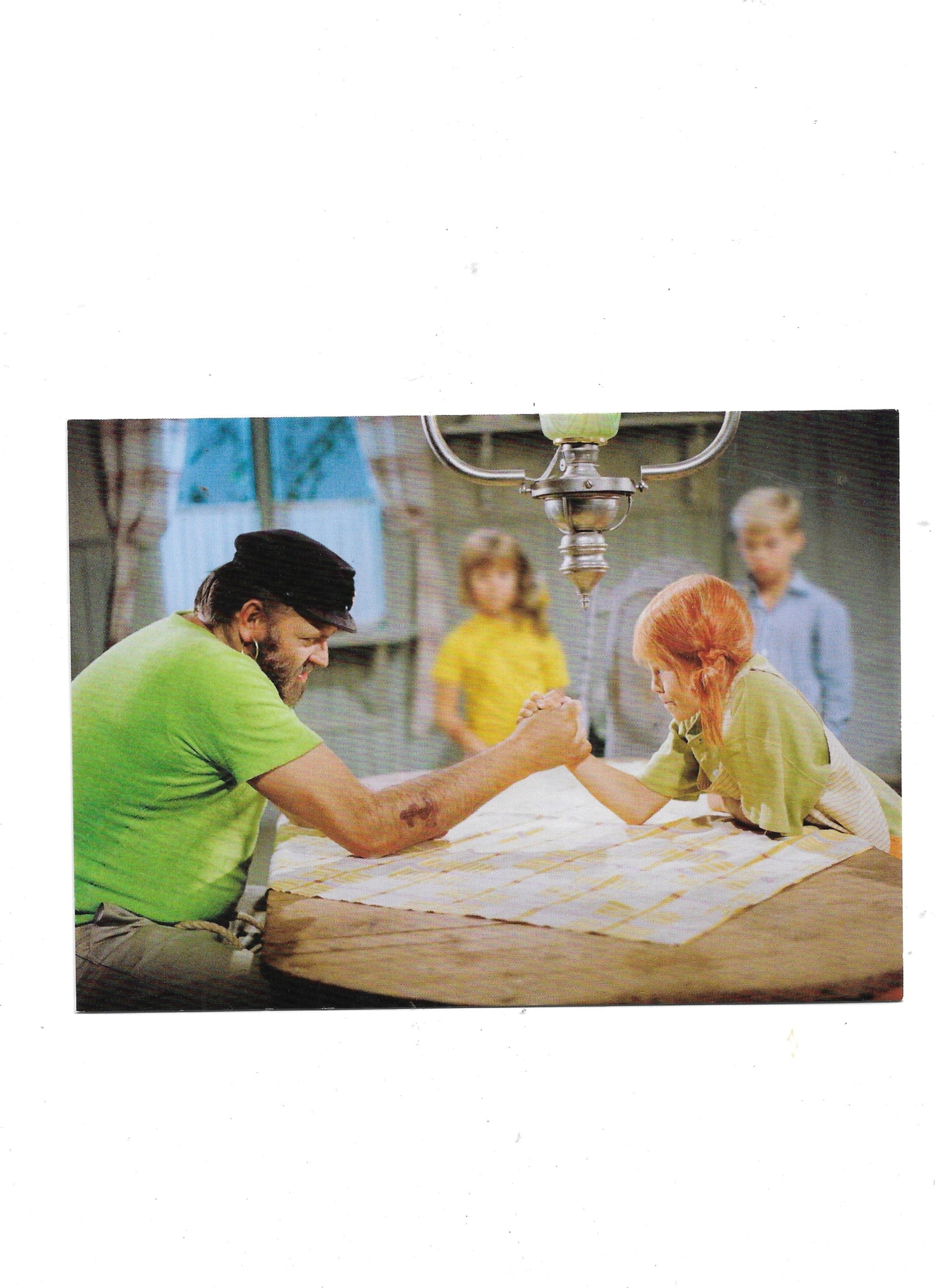 „Postkarte A6 ‚Pippi Langstrumpf – Inger Nielsson und Papa beim Armdrücken‘; stabiles Papier, satte Farben, gute Druckqualität, Format 10,5 × 14,8 cm, neu, EAN 4030576501331, Hersteller Anderskartig – Modern Times GmbH“ 