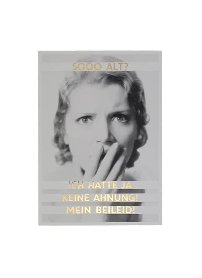 „Schwarz-weiße Postkarte mit einer überraschten Person, die sich erschrocken die Hand vor den Mund hält. Goldener Text: ‚SOOO ALT? ICH HATTE JA KEINE AHNUNG! MEIN BEILEID!‘ – ein frecher Geburtstagsgruß mit schwarzem Humor.“