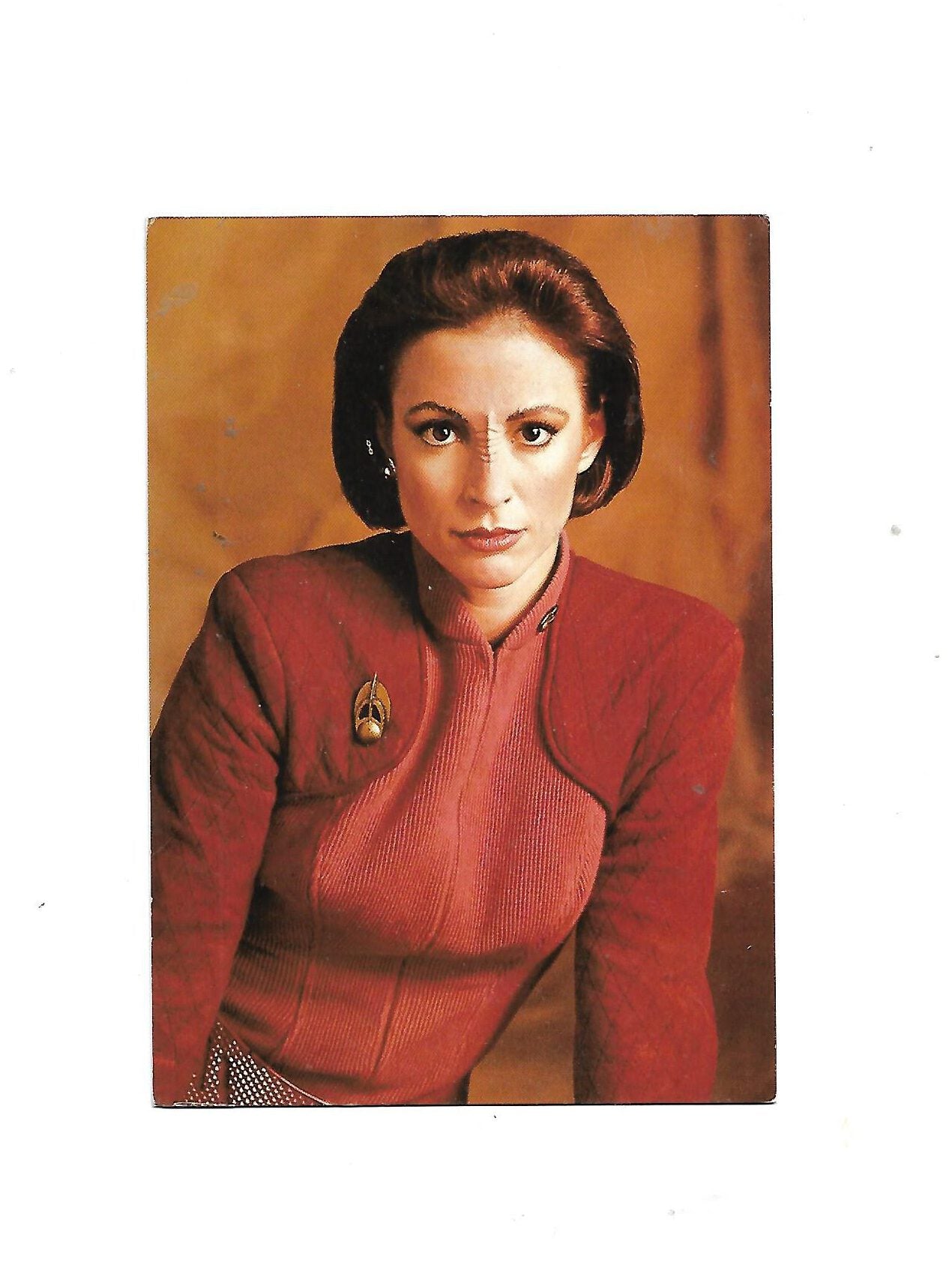 „Postkarte A6 ‚Star Trek – Deep Space Nine – Major Kira Nerys‘; stabiles Papier, satte Farben, gute Druckqualität, Format 10,5 × 14,8 cm, Rückseite leicht fleckig, ohne EAN, Hersteller M + V Marketing Verlags GmbH, Wuppertal, 1994.“  
