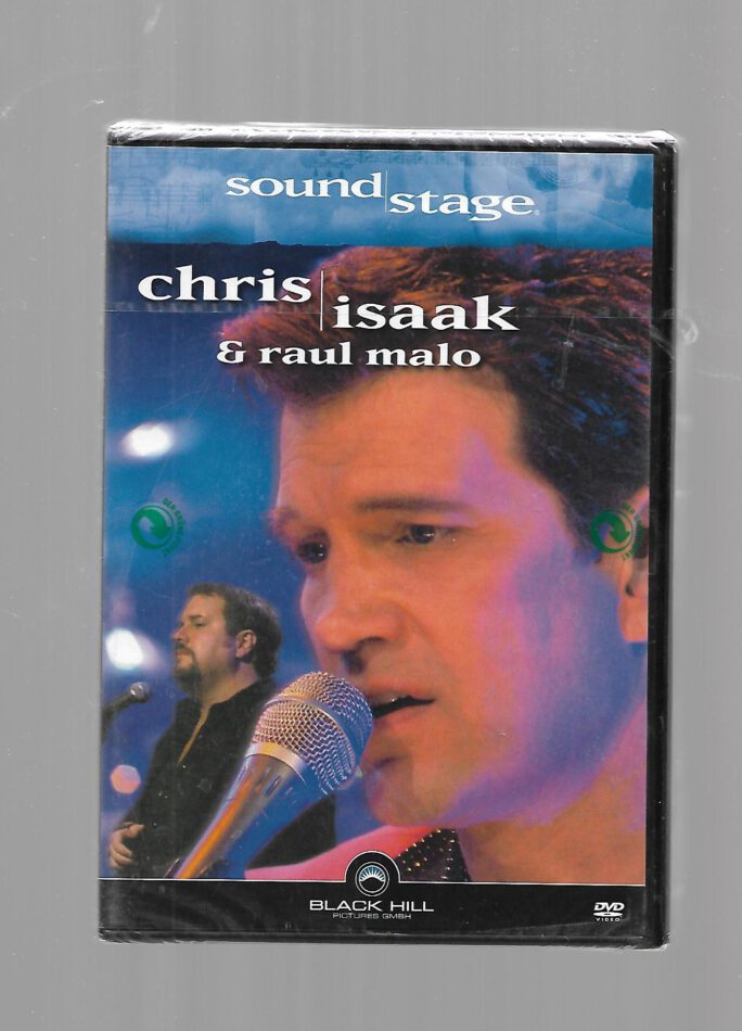 „Chris Isaak in Konzertaufnahme, umgeben von Bühnenlicht und Retro-Atmosphäre – visuelle Verkörperung von Sehnsucht und Stil.“