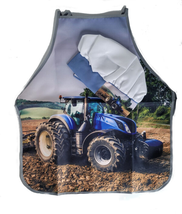 kinderschürze mit dem Motiv eines blauen Traktors auf dem Feld und dazugehörig eine Kochmütze in weiß und ebenfalls auf der Umrandung mit einem Traktormotiv versehen